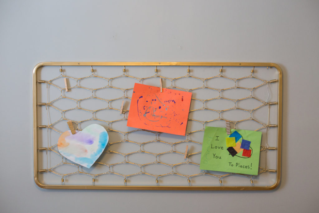 Create a DIY artwork display using an old crib spring for easy storage for those papers your kids bring home from school everyday.